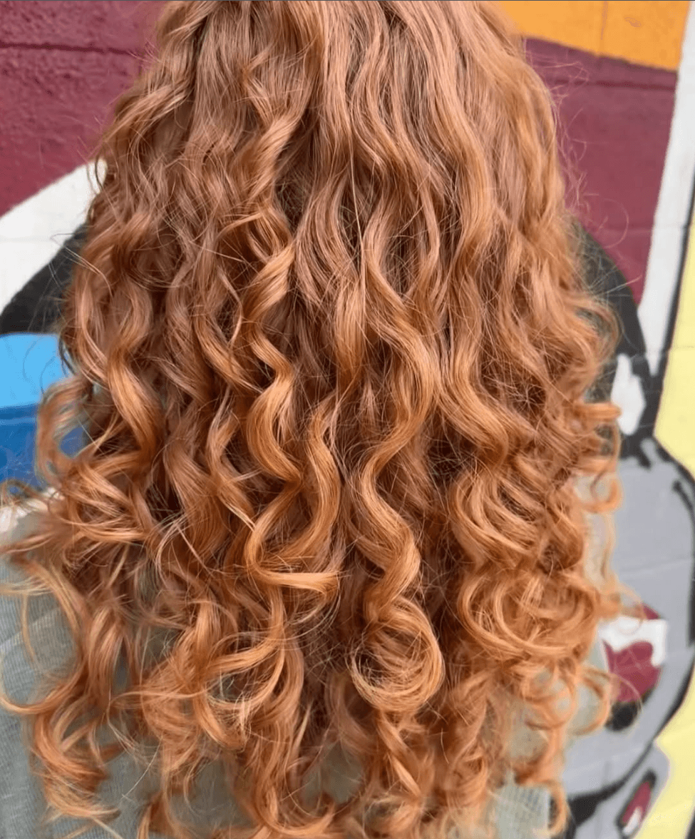 Warm copper-strawberry blonde on long defined curls